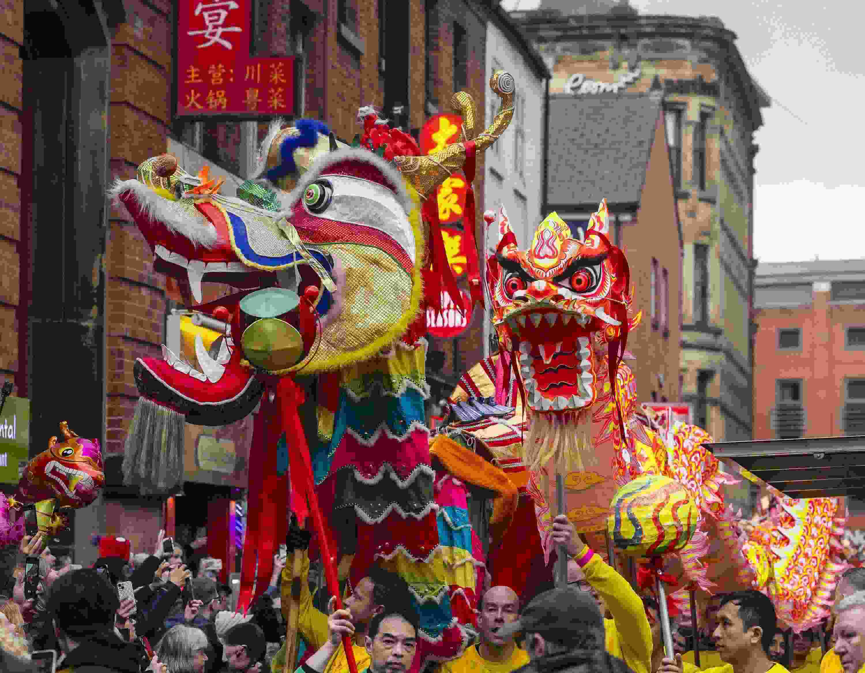 △ 當?shù)貢r間2024年2月11日，英國曼徹斯特，表演者進入中國城，參加中國農(nóng)歷龍年春節(jié)的慶?；顒印? width=