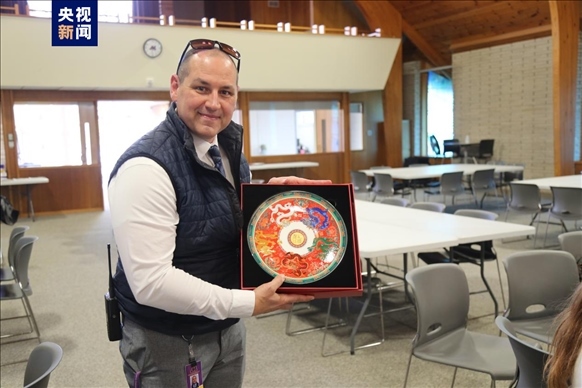 △馬斯卡廷中學高中部校長瑞安·卡斯爾代表學校接受總臺文創(chuàng)產品