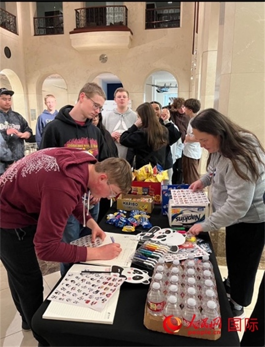 學生們出發(fā)前紛紛在留言簿留言。人民網(wǎng)記者 鄧圩攝