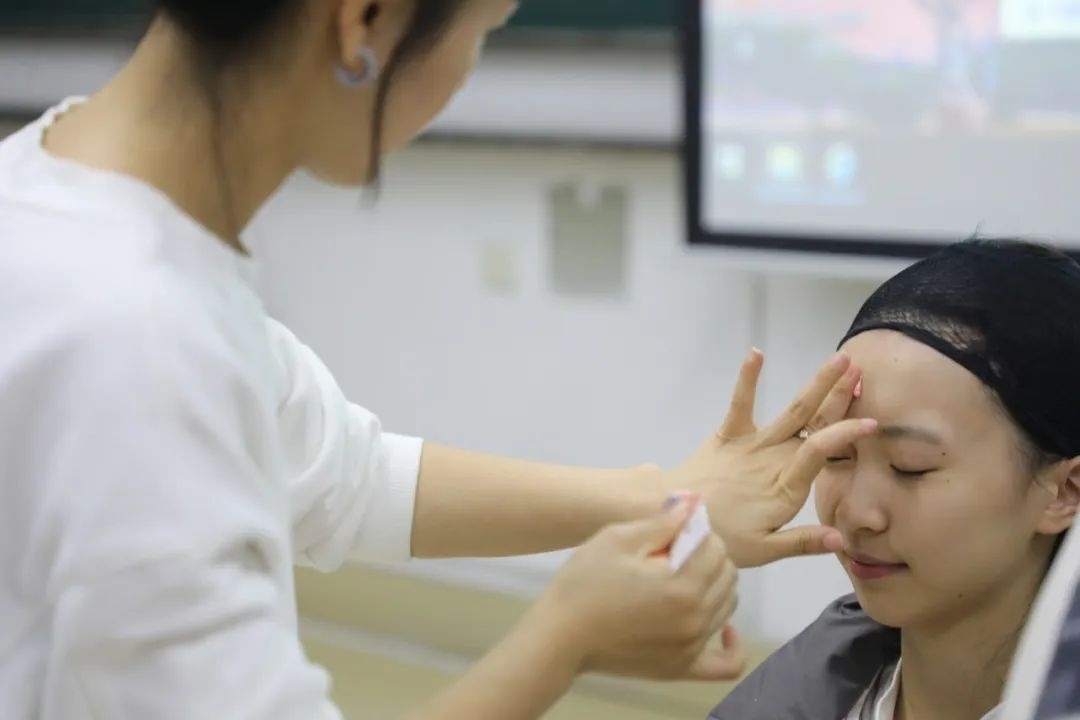 課堂上，一名學(xué)生在體驗(yàn)上戲妝。學(xué)校供圖