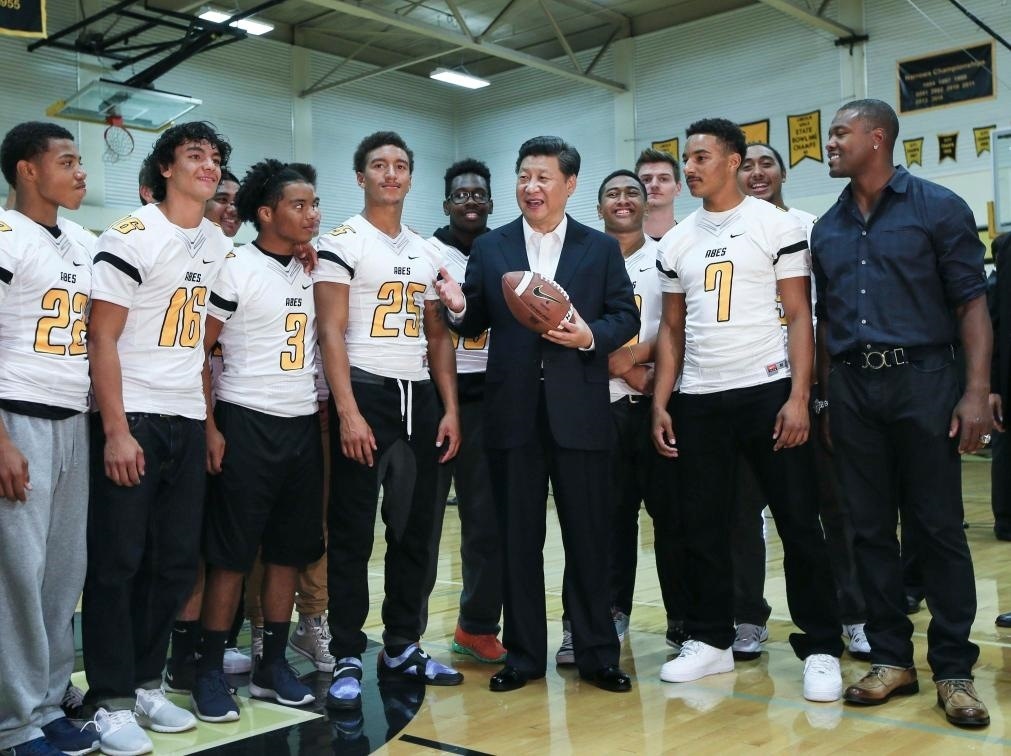 2015年9月23日，國(guó)家主席習(xí)近平參觀美國(guó)塔科馬市林肯中學(xué)。這是習(xí)近平在學(xué)校體育館，同上橄欖球訓(xùn)練課的學(xué)生們親切交談。新華社記者 蘭紅光 攝