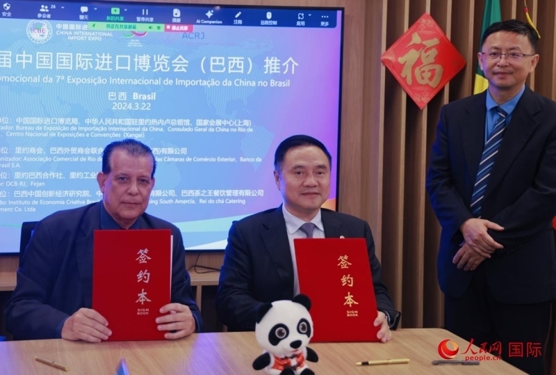 巴西外貿(mào)商會(huì)聯(lián)合會(huì)會(huì)長阿代爾·羅伯托（左）與中國國際進(jìn)口博覽局副局長吳政平（中）現(xiàn)場簽訂協(xié)議。人民網(wǎng)記者 宋亦然攝