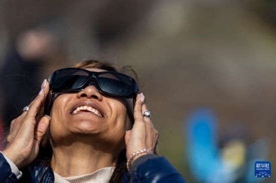 4月8日，一名女子在美國(guó)紐約州普拉茨堡觀看日食。新華社發(fā)（文森特·約翰遜攝）