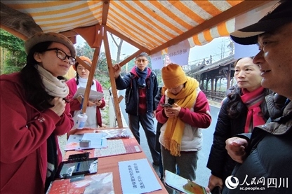 1月6日，“2024成都蒲江柑甜采摘節(jié)”上，記者見到了小萌（左一）和許多年輕人忙著做訪客接待、現(xiàn)場布置、票務(wù)核對、采摘服務(wù)等工作。人民網(wǎng)記者朱虹攝