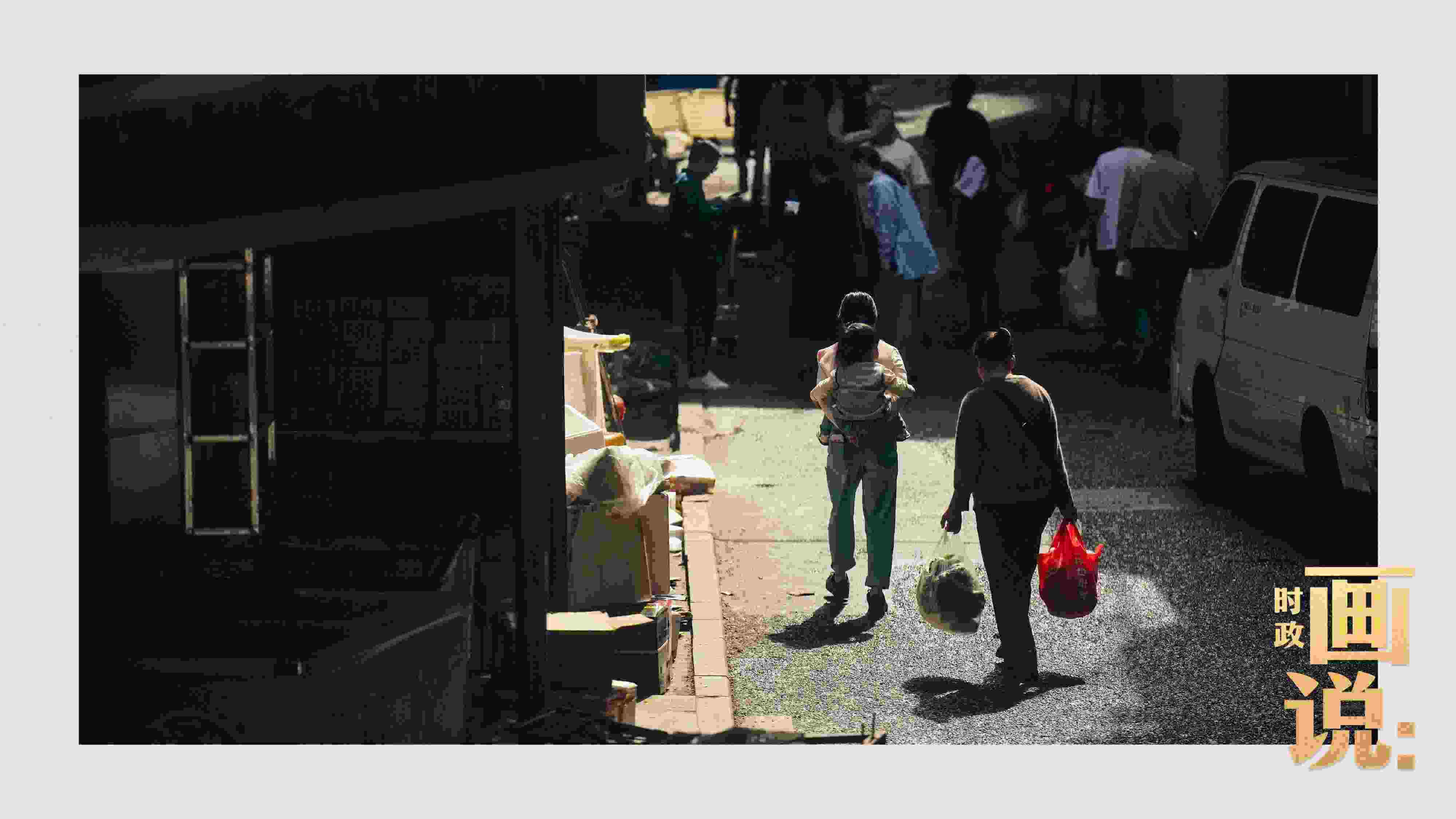 △老城區(qū)鱗次的樓宇間漏下一縷光，路人走過(guò)暖陽(yáng)。