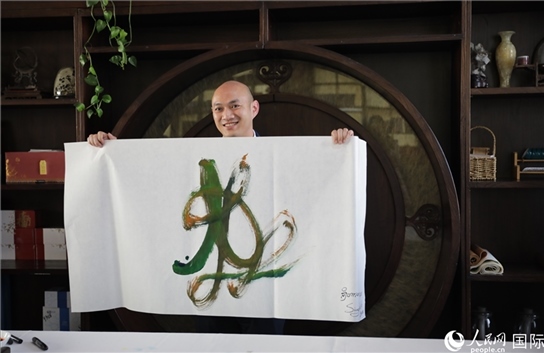 老撾駐華大使館三秘明君參加《五百筆·瀾湄合作》集體藝術(shù)創(chuàng)作。人民網(wǎng)王婧攝。