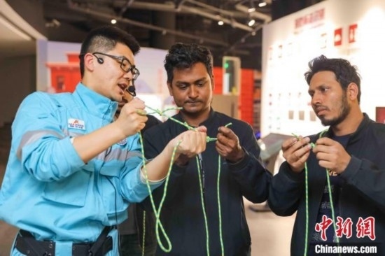 5月9日，工作人員指導(dǎo)留學(xué)生學(xué)習(xí)打繩結(jié)。張鷹 攝