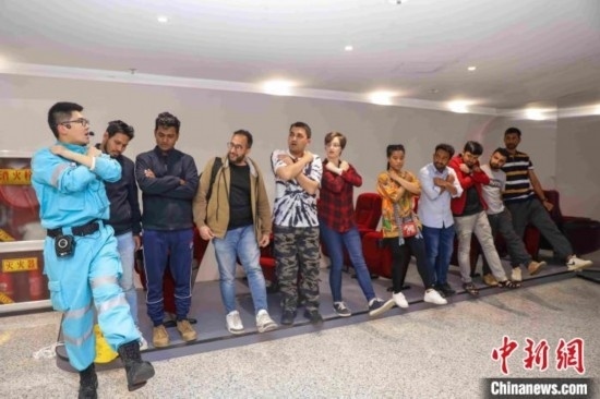 5月9日，工作人員指導(dǎo)留學(xué)生練習(xí)逃生技巧。張鷹 攝