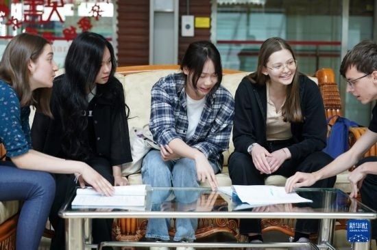 4月28日，宋智孝（右二）和胡靈月（左一）在北京首都師范大學校園內與同學交流。新華社記者 彭子洋 攝