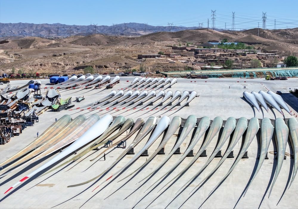 2024年5月11日拍攝的碼放在內(nèi)蒙古包頭市石拐區(qū)一家風(fēng)電設(shè)備制造企業(yè)廠區(qū)內(nèi)的葉片（無人機(jī)照片）。新華社記者 連振 攝