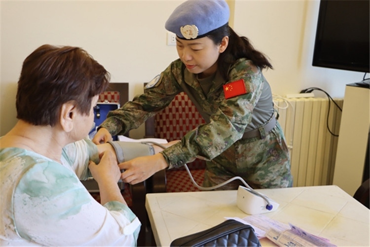 【1】 醫(yī)療分隊隊員為當?shù)鼗颊邷y量血壓。曾德樂攝