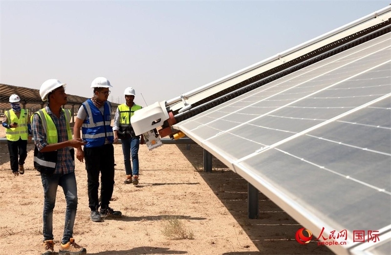 工作人員在測試自動(dòng)清掃機(jī)器人。人民網(wǎng)記者管克江攝