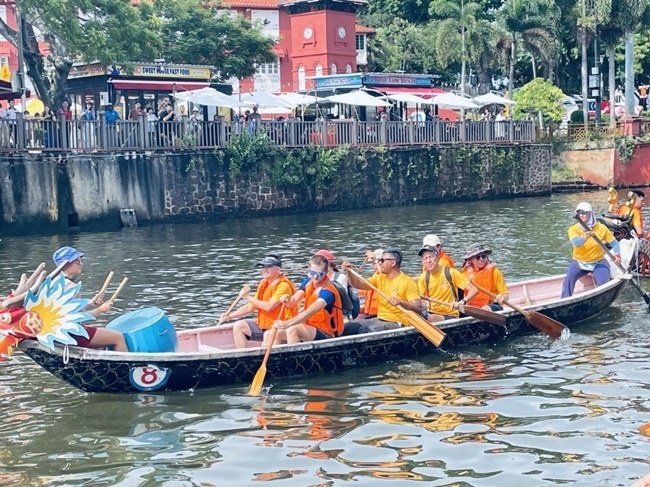 多元種族共同奮輯前進(jìn)，體驗在馬六甲河劃龍舟，引來大批游客駐足圍觀。組委會供圖
