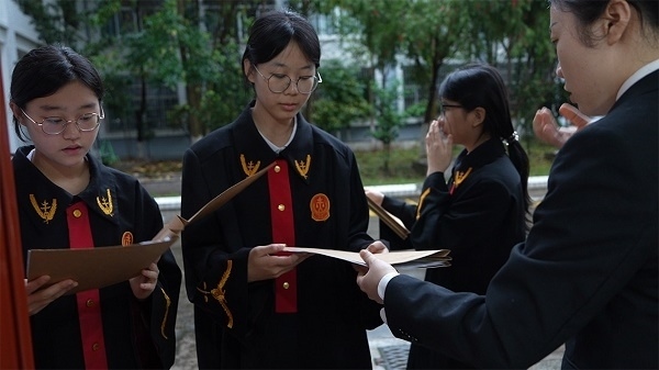 圖①：武平法院干警向?qū)W生分發(fā)道具卷宗。