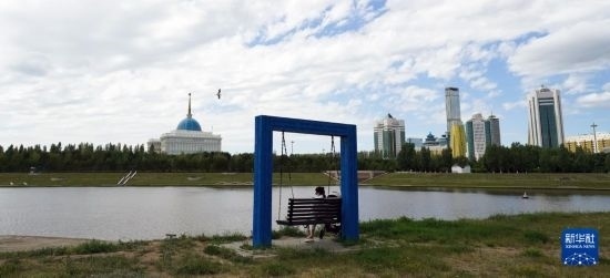 6月30日，一名女子在哈薩克斯坦首都阿斯塔納伊希姆河畔休息。新華社記者 王建華 攝