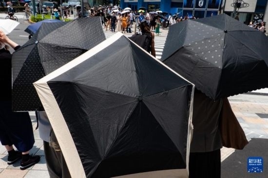 7月4日，人們?cè)谌毡緰|京原宿的街道上等待紅綠燈。新華社記者 張笑宇 攝