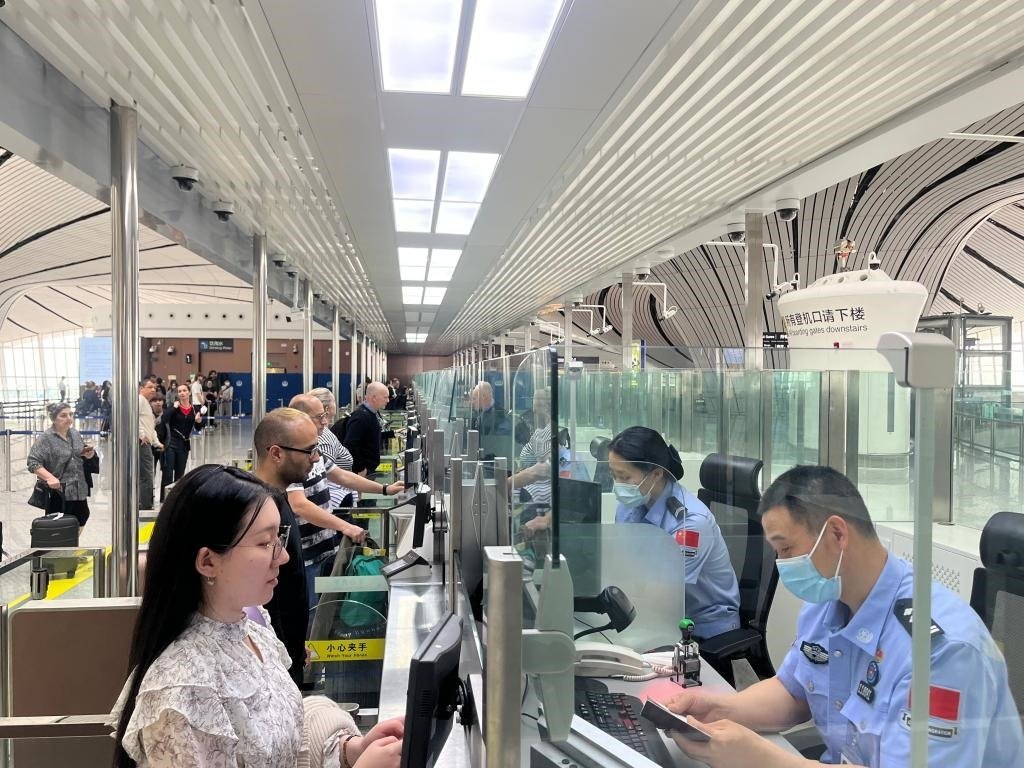 7月5日，北京大興國際機(jī)場邊檢站民警正在辦理邊檢查驗(yàn)手續(xù)。（北京大興國際機(jī)場邊檢站供圖）