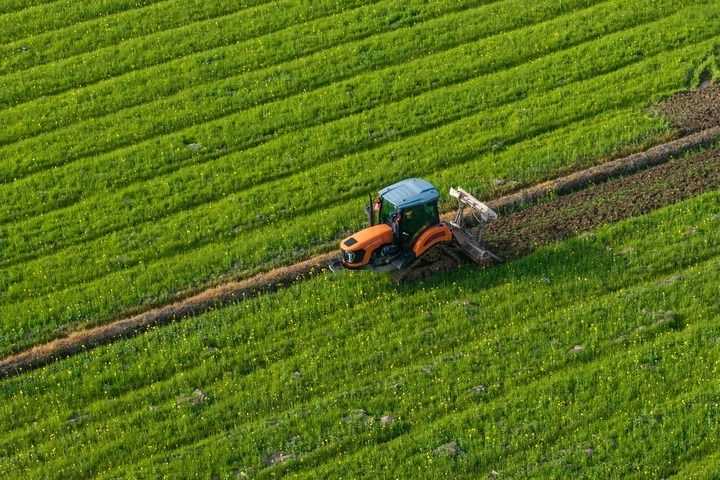 2024年3月19日，在湖南省常德市鼎城區(qū)謝家鋪鎮(zhèn)港中坪村，村民駕駛農(nóng)機(jī)翻耕田地（無(wú)人機(jī)照片）。新華社記者 陳思汗 攝