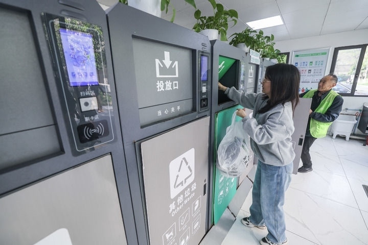2024年4月10日，在浙江省湖州市吳興區(qū)飛英街道新華府小區(qū)內(nèi)，居民在垃圾分類智能系統(tǒng)的指導(dǎo)下進(jìn)行垃圾分類投放，居民的投放情況將實(shí)時(shí)匯總到智慧服務(wù)平臺(tái)，會(huì)有相應(yīng)的積分獎(jiǎng)勵(lì)。新華社記者 徐昱 攝