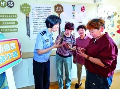 浙江湖州民警指導居民加入湖州“e企安”微信群，實時接收反詐信息。新華社發(fā)