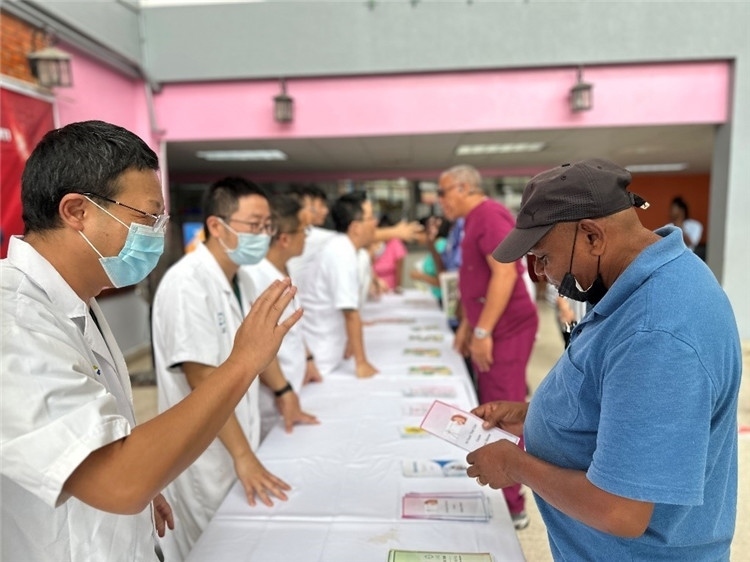 援圭醫(yī)療隊(duì)隊(duì)員們在啟動(dòng)儀式上為當(dāng)?shù)孛癖姺职l(fā)宣傳手冊。中國援助圭亞那醫(yī)療隊(duì)供圖