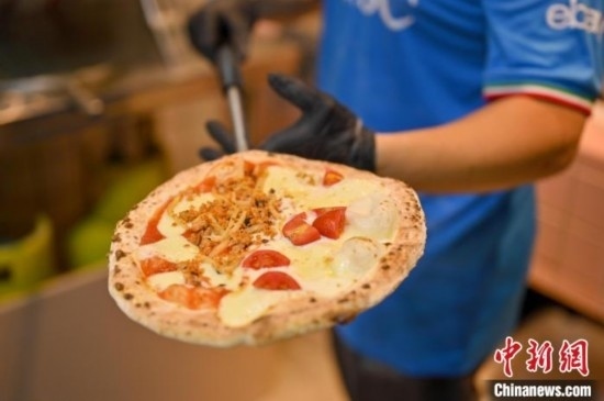 近日，韋榮耀展示他制作的“老友味”披薩。 俞靖 攝