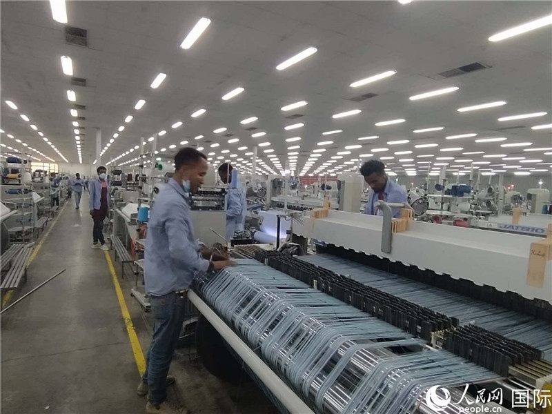 無錫金茂埃塞面料廠車間內(nèi)，當(dāng)?shù)毓と苏谝唤z不茍地作業(yè)。人民網(wǎng)記者 黃培昭攝