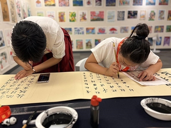 參加本次展覽的青少年在現(xiàn)場進(jìn)行書法創(chuàng)作。主辦方供圖
