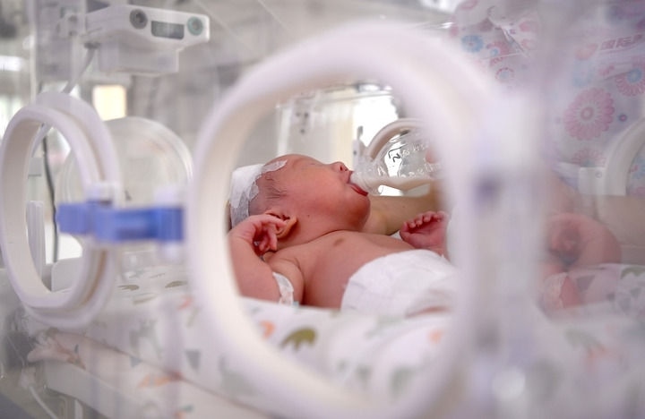 2024年6月1日，在西安國際醫(yī)學(xué)中心醫(yī)院新生兒科病房，護(hù)士為新生兒喂奶。 新華社記者 劉瀟 攝