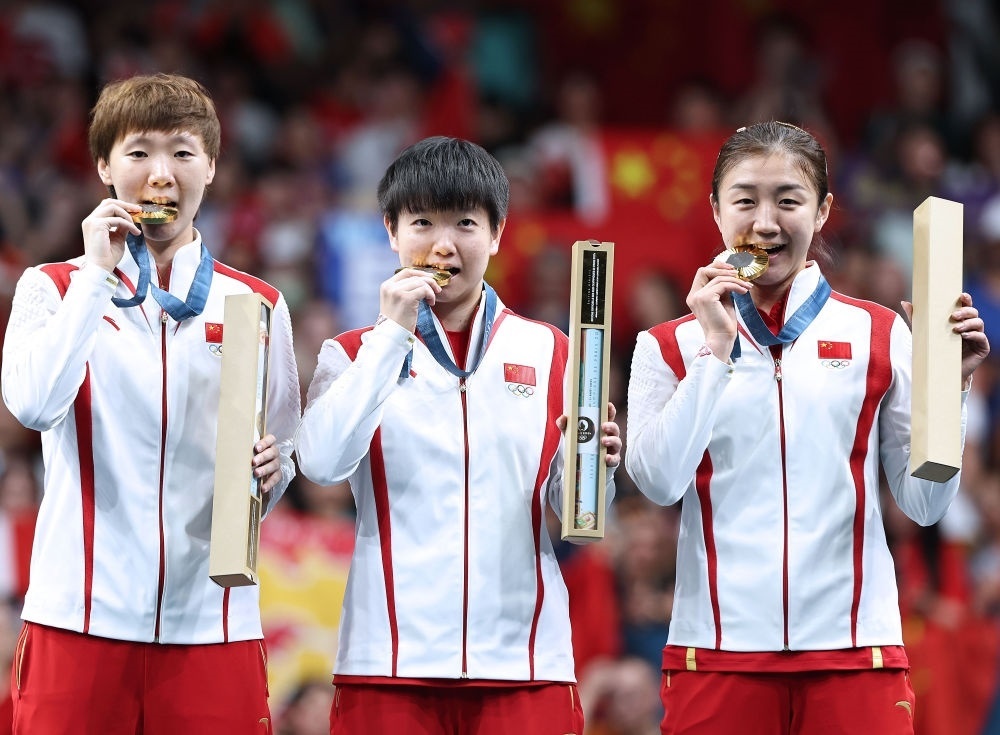 冠軍中國隊(duì)選手王曼昱、孫穎莎、陳夢（從左至右）在巴黎奧運(yùn)會乒乓球女子團(tuán)體頒獎儀式上（2024年8月10日攝）。新華社記者 王東震 攝
