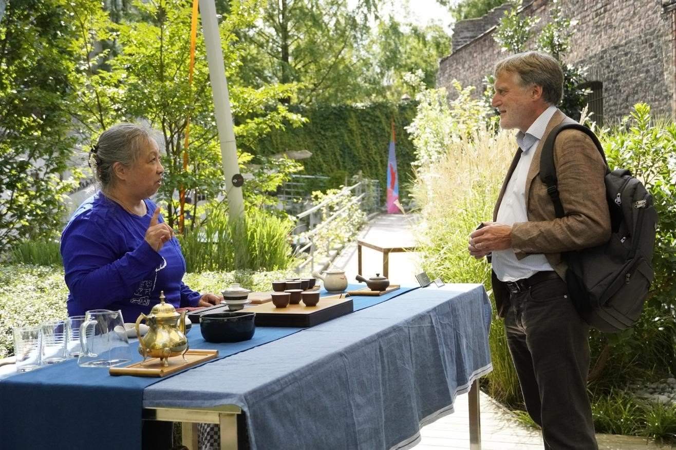 在博物館的戶外花園來賓品味中國茶藝。比利時(shí)維他命文化傳媒供圖