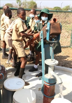 △2021年11月，在津巴布韋南馬塔貝萊蘭省省會(huì)關(guān)達(dá)的塞農(nóng)多小學(xué)，學(xué)生從中國(guó)援建水井里打水。