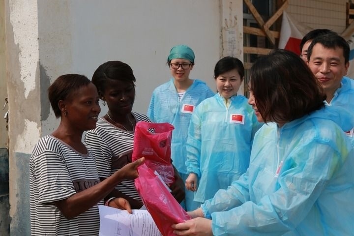 2015年4月4日，在位于塞拉利昂首都弗里敦市郊的中塞友好醫(yī)院埃博拉診療中心，中國第四批援塞醫(yī)療隊(duì)副隊(duì)長邵蔚（右前）向被治愈的埃博拉出血熱患者贈送禮物。新華社發(fā)（祖榮強(qiáng) 攝）