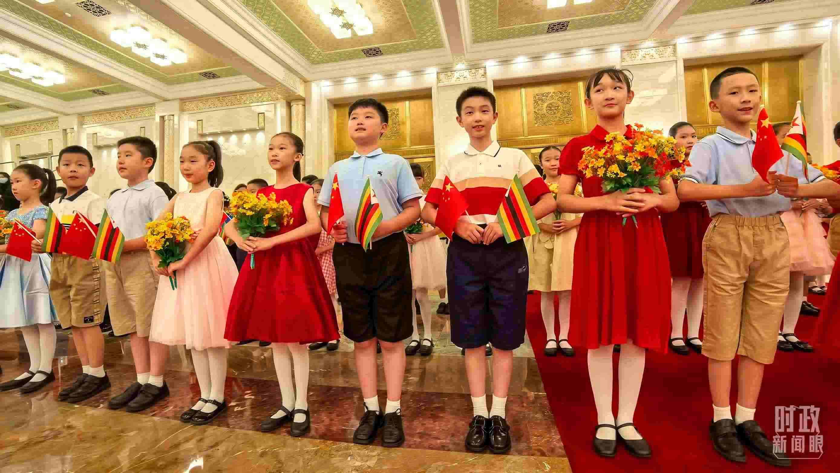 △現(xiàn)場歡迎津巴布韋總統(tǒng)訪華的青少年。（總臺(tái)央視記者鐘銳拍攝）