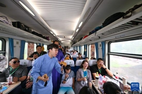 9月7日，相聲演員在S910列車上為旅客表演快板。