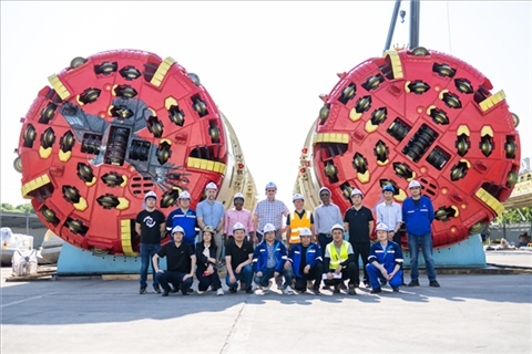 中外員工在盾構(gòu)機(jī)前合影。中國電建供圖