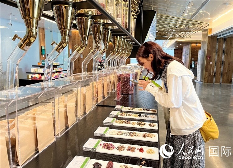 4. 代表團(tuán)團(tuán)員對新中式茶飲的食材充滿興趣。（人民網(wǎng)記者陳思 攝）
