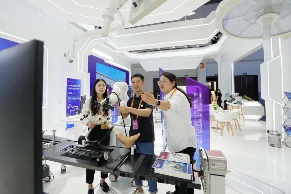 9月11日，一位媒體記者（中）在2024年服貿(mào)會(huì)國(guó)家會(huì)議中心會(huì)場(chǎng)體驗(yàn)北京納通科技集團(tuán)有限公司的膝關(guān)節(jié)置換手術(shù)機(jī)器人。新華社記者鞠煥宗 攝