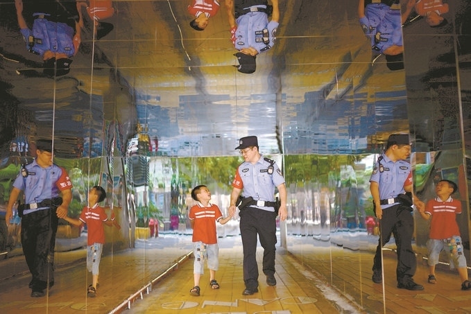 ?7月16日，重慶市公安局江北區(qū)分局一名民警在巡邏途中遇到一個獨自玩耍的小男孩，民警將其送回家。王洪平攝