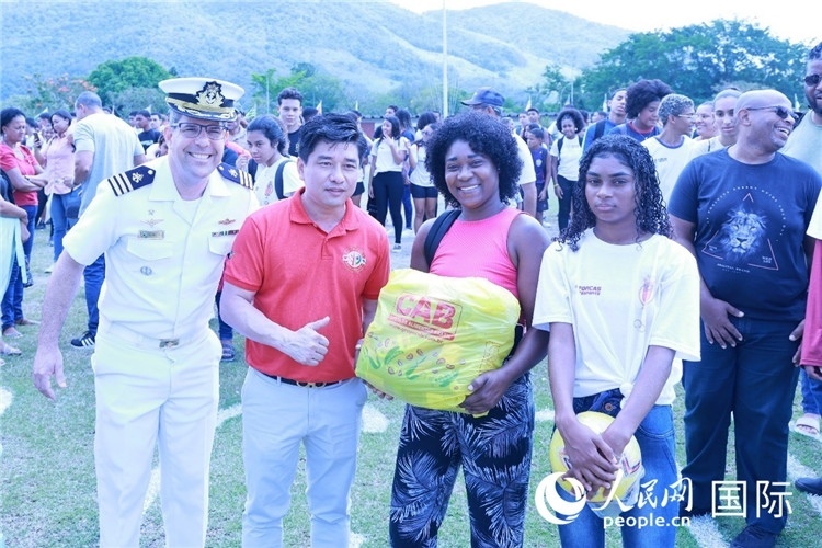 巴西中國浙江商會會長鄭俠茂向巴西貧困社區(qū)兒童及家庭捐贈基礎食品籃子和足球。人民網(wǎng)記者陳海琪 攝