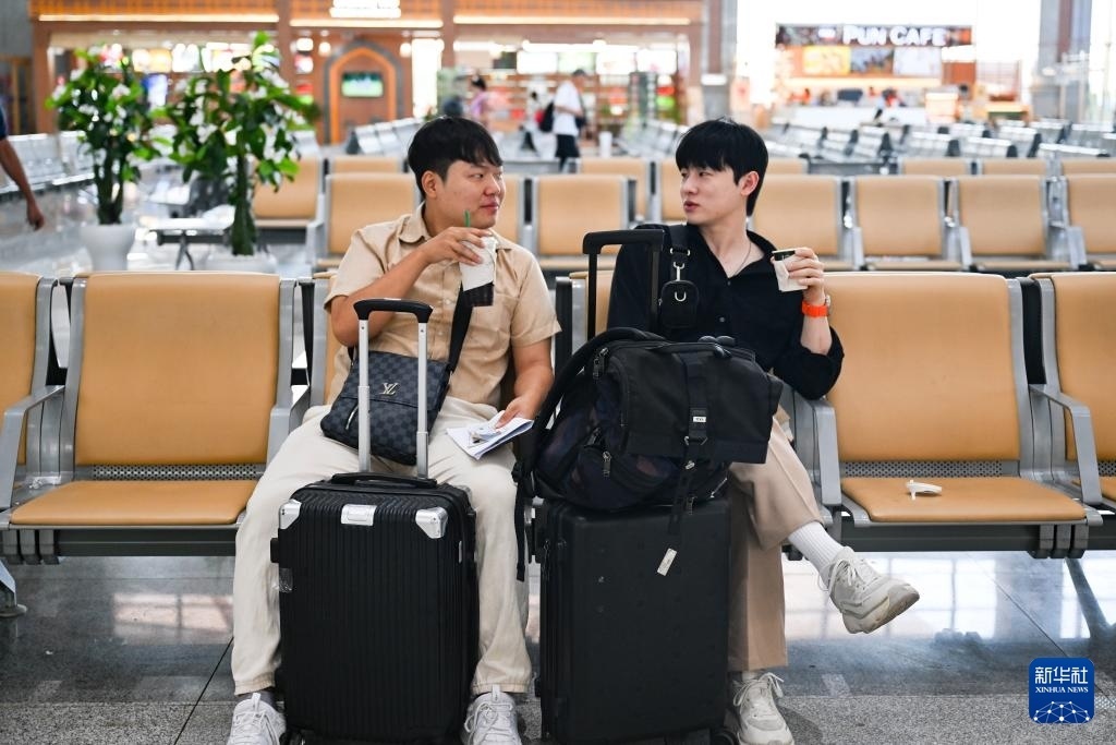 10月12日，在老撾萬(wàn)象中老鐵路萬(wàn)象站候車(chē)廳，兩名乘客在等候列車(chē)。新華社記者 程一恒 攝