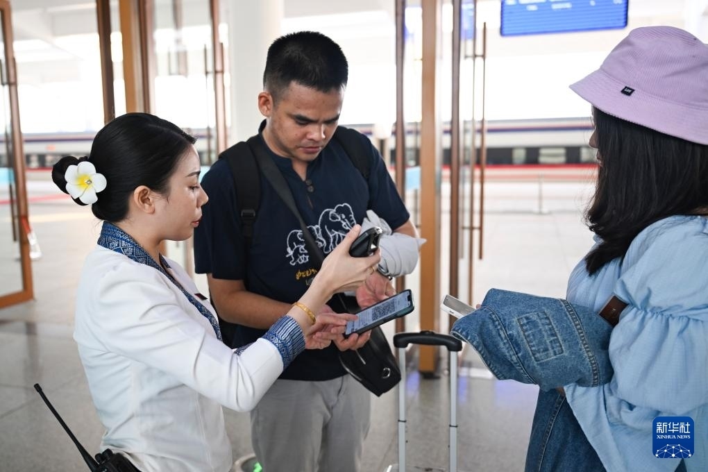 10月12日，在老撾萬(wàn)象中老鐵路萬(wàn)象站，工作人員檢驗(yàn)乘客車(chē)票。新華社記者 程一恒 攝