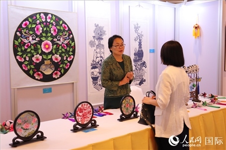 青海非遺文化傳承人向嘉賓介紹展品。人民網(wǎng)實(shí)習(xí)生姚欣可攝