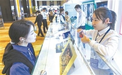 在北京麗澤商務區(qū)，工作人員（右一）介紹數(shù)字人民幣SIM卡硬錢包。新京報記者 陶冉攝