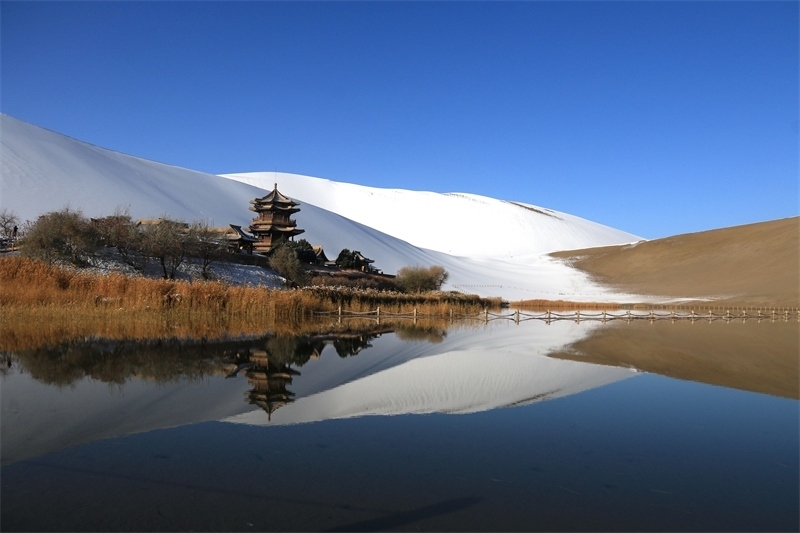 鳴沙山月牙泉景區(qū)雪景。敦煌市委宣傳部供圖，張曉亮攝