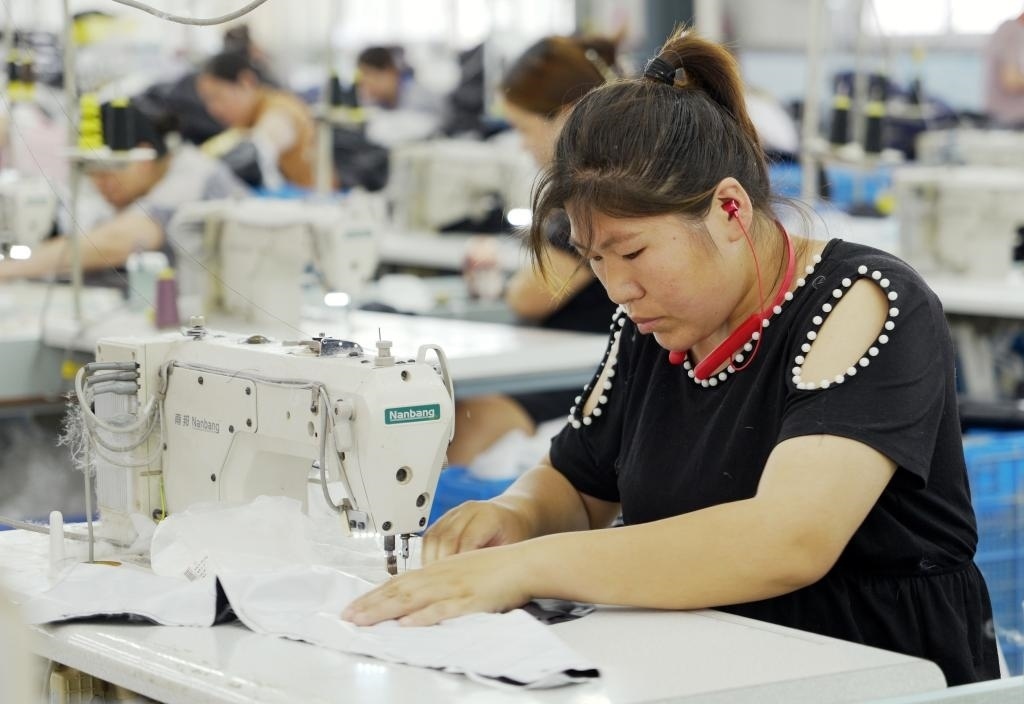 5月20日，村民在李寨村服裝加工廠內(nèi)忙碌。河南省周口市沈丘縣馮營鎮(zhèn)李寨村地處豫東平原。近年來，乘著脫貧攻堅(jiān)與鄉(xiāng)村振興政策的東風(fēng)，李寨村積極探索產(chǎn)業(yè)發(fā)展模式，通過“龍頭企業(yè)+村集體經(jīng)濟(jì)+農(nóng)戶”的方式，逐漸發(fā)展形成肉牛養(yǎng)殖、設(shè)施農(nóng)業(yè)、服裝加工、康養(yǎng)民宿等產(chǎn)業(yè)，以產(chǎn)業(yè)振興助力鄉(xiāng)村振興。新華社記者 李嘉南 攝