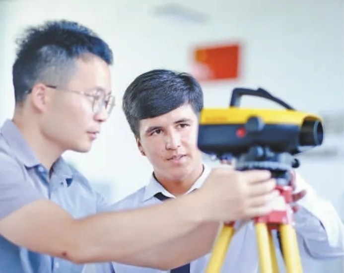 在塔吉克斯坦首都杜尚別的魯班工坊，來自天津城市建設(shè)管理職業(yè)技術(shù)學(xué)院的老師（左）為當(dāng)?shù)貙W(xué)生提供指導(dǎo)。新華社記者 鄭開君 攝