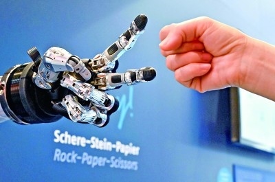 在德國漢諾威工博會(huì)上，參觀者與一款智能機(jī)器人進(jìn)行“石頭剪子布”游戲。新華社發(fā)