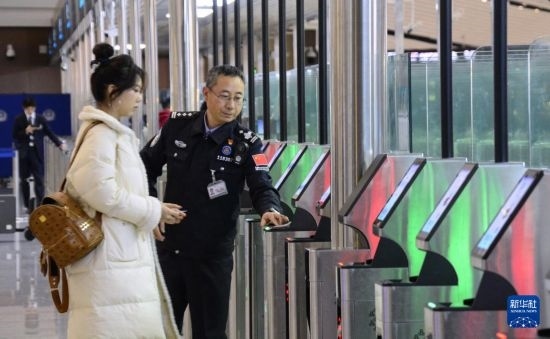 1月2日，大興機場邊檢站警察指導(dǎo)旅客使用自助出境設(shè)備。新華社記者 李欣 攝