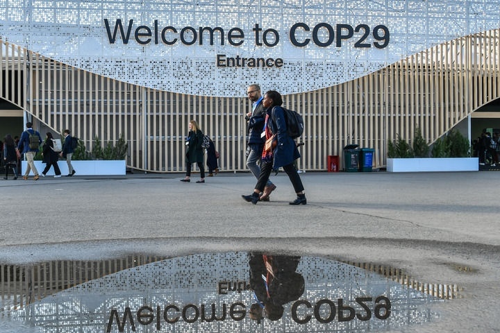 2024年11月15日，在阿塞拜疆首都巴庫(kù)，人們經(jīng)過(guò)聯(lián)合國(guó)氣候變化巴庫(kù)大會(huì)的會(huì)場(chǎng)。新華社記者 曹陽(yáng) 攝